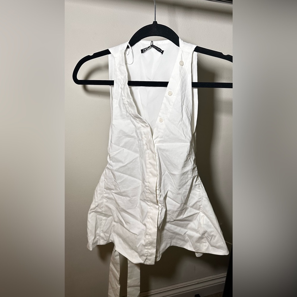 New poplin white sleeveless button down with cutout back and bow. Size M